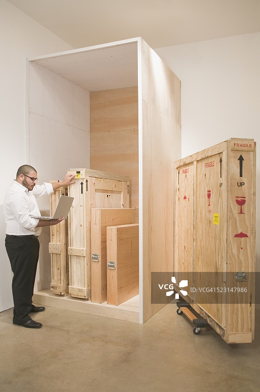 使用笔记本电脑跟踪货运的艺术品商人图片素材