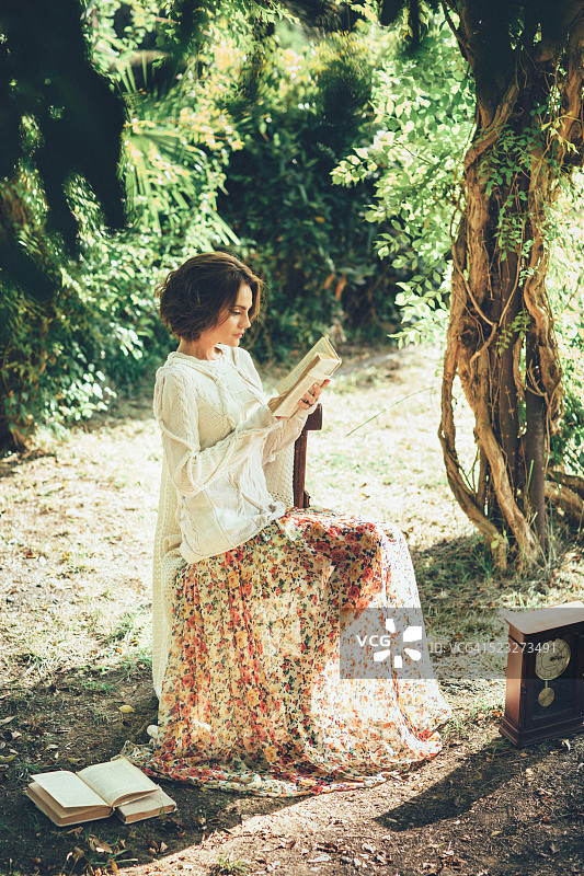 在魔法公园里看书的美丽女人图片素材