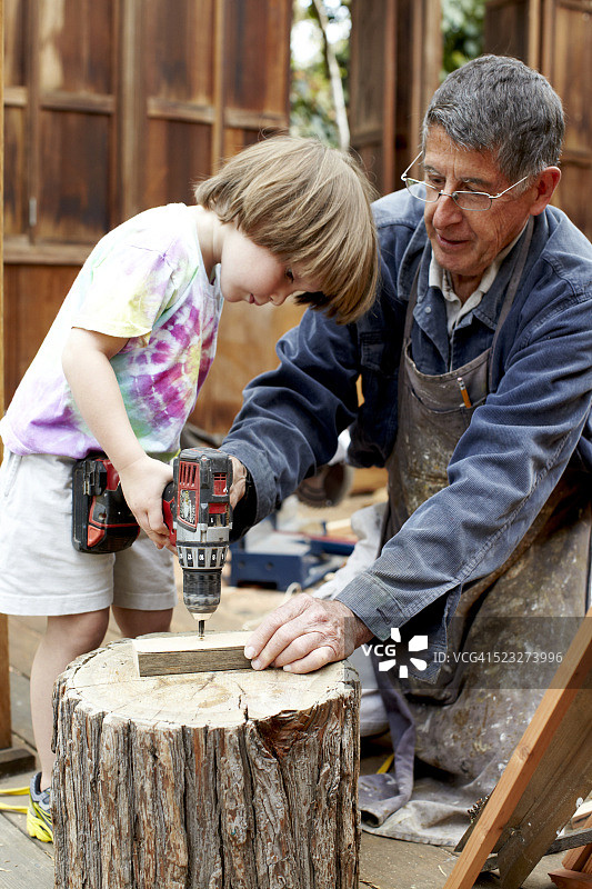 爷爷和孙子（4-5岁）用铅笔做标记图片素材