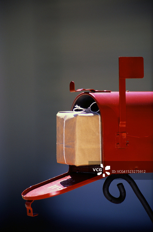 打开的邮箱中的棕色纸质包裹图片素材