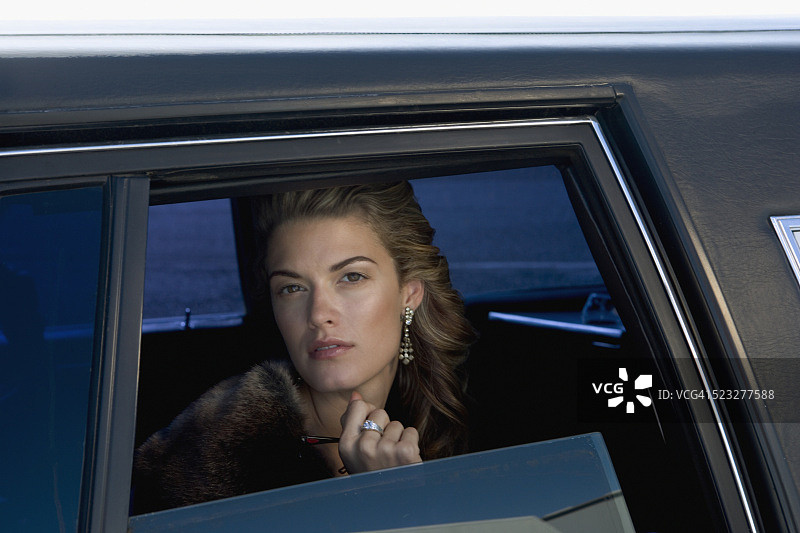 女子在豪华轿车里向外看图片素材