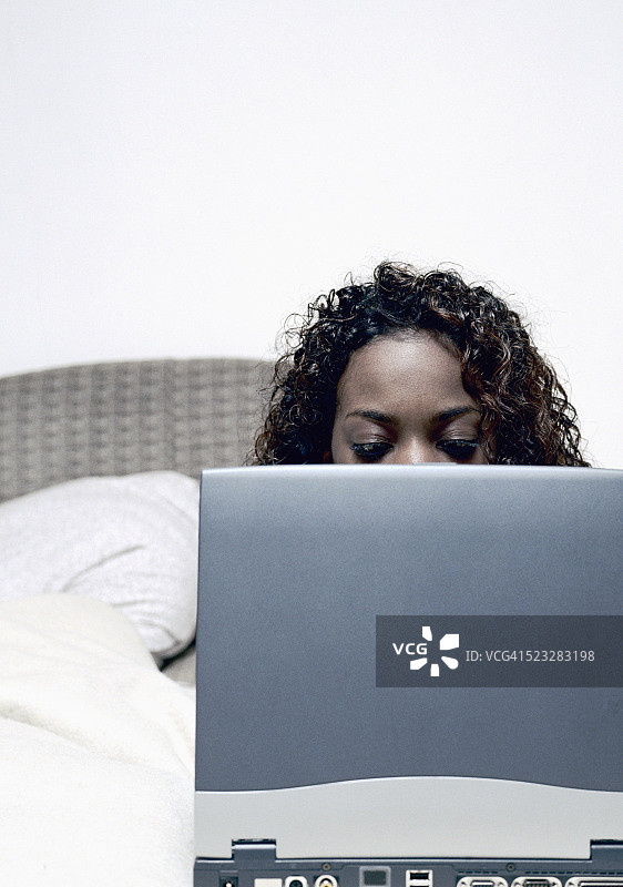 女人在床上使用笔记本电脑图片素材