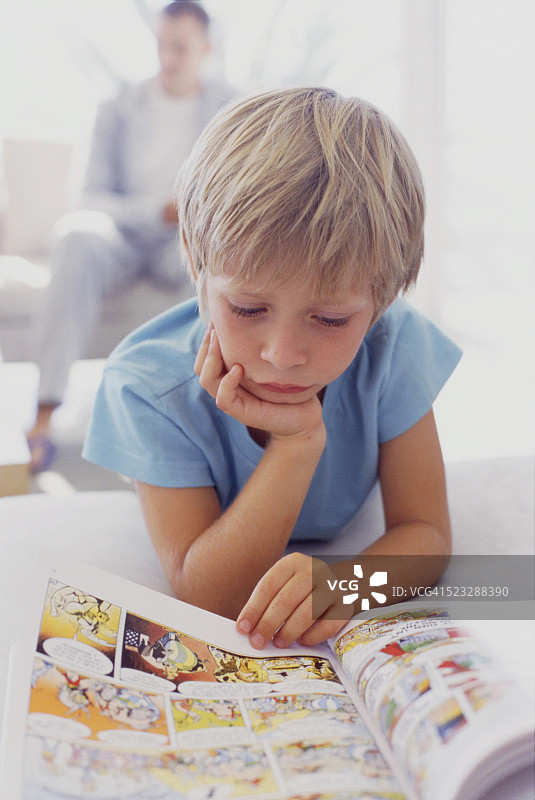 男孩在读漫画书图片素材