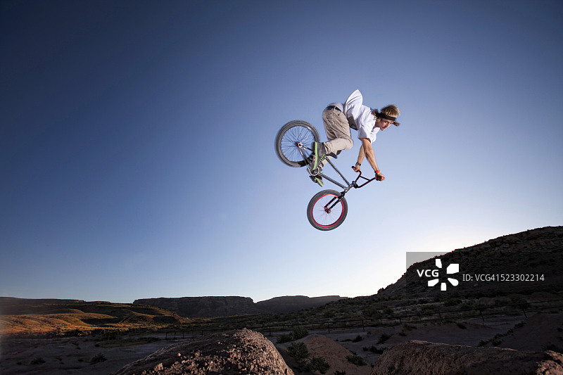 青少年骑BMX自行车越过土坡图片素材