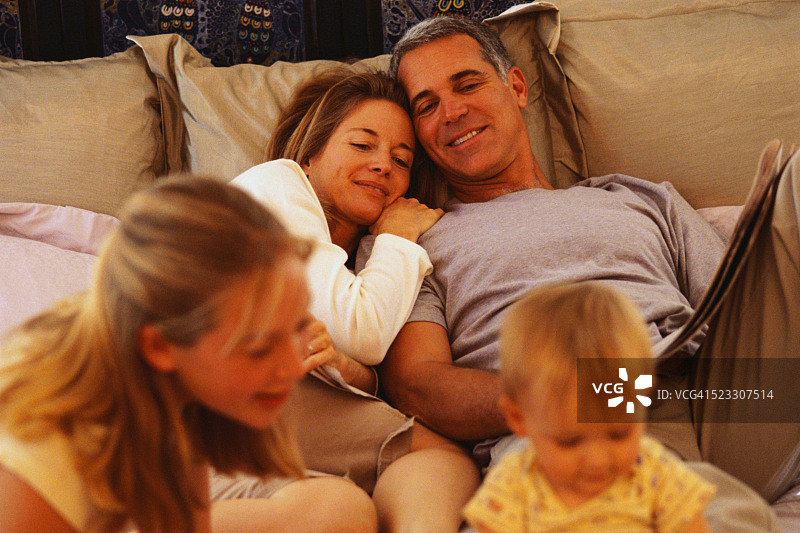 父母和孩子在床上放松图片素材