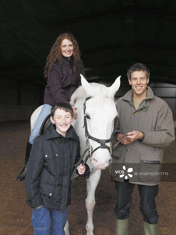 在马厩里的女人、男人和男孩图片素材