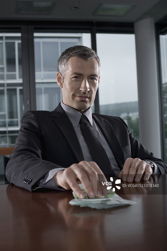 商务人士将欧元钞票放在桌子上图片素材