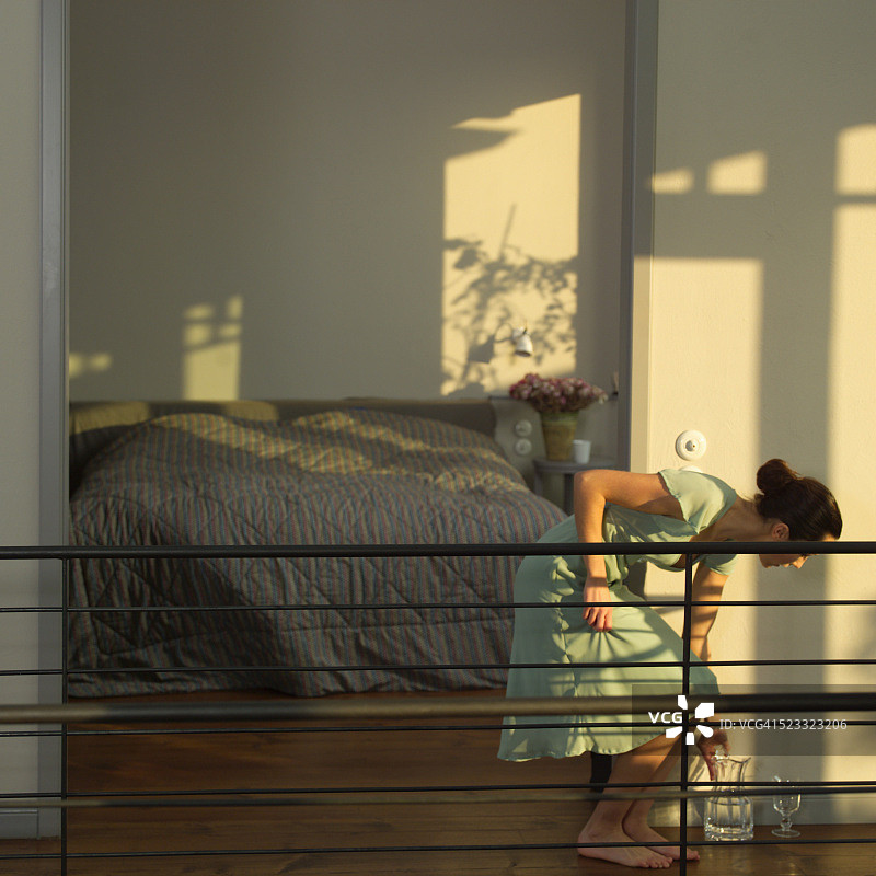 年轻女子伸手拿水壶图片素材