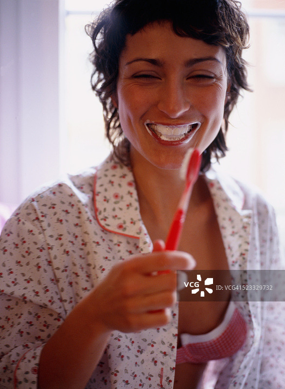 在卧室里刷牙的年轻女子图片素材