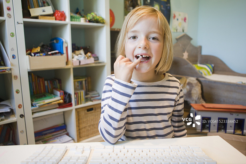 小女孩在网络视频通话中展示掉落的牙齿图片素材