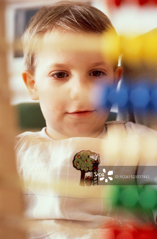 小男孩坐在算盘后图片素材