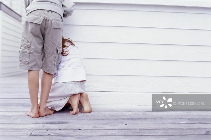 男孩和女孩躲在房子后面图片素材