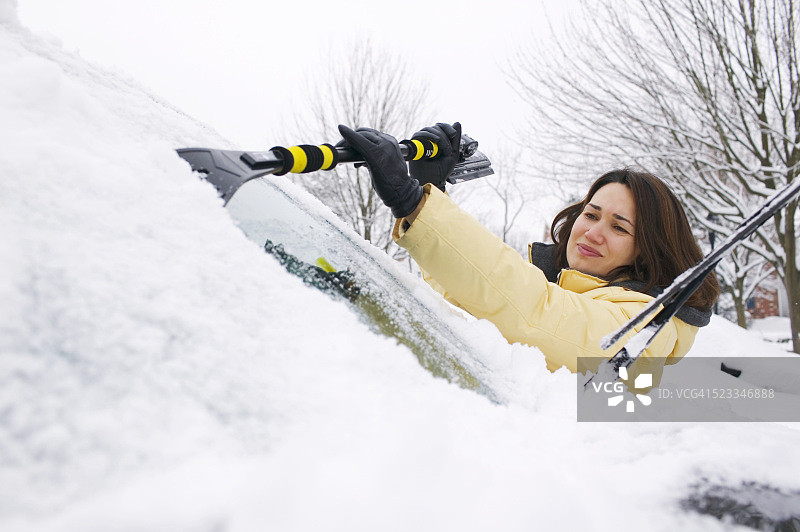 女人移除挡风玻璃上的雪图片素材