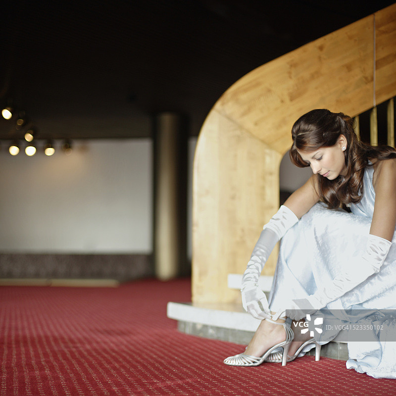 女人在楼梯间系紧高跟鞋图片素材