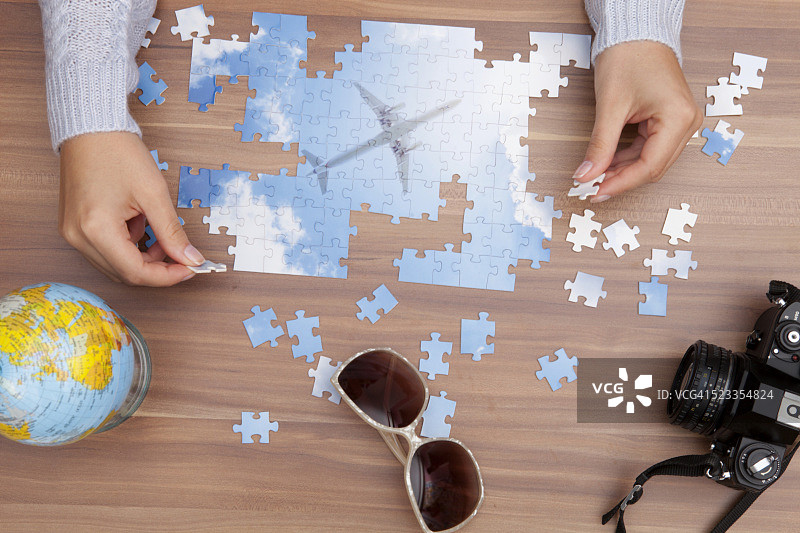 俯视：女性双手拼飞机图案拼图图片素材