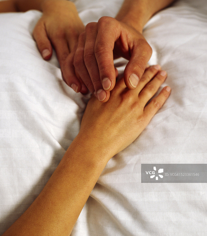 情侣在白色毯子上的手图片素材