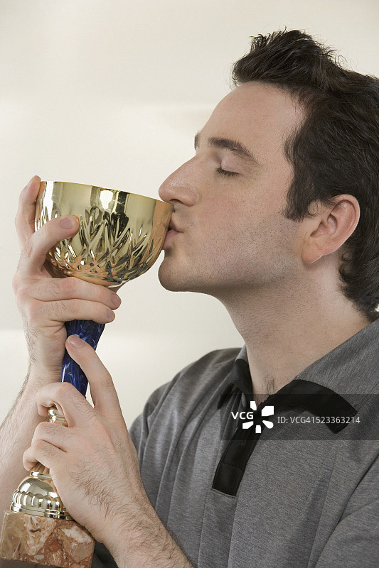 亲吻杯子的年轻男人图片素材