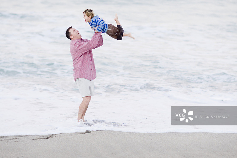 男人在海滩上和儿子玩耍图片素材
