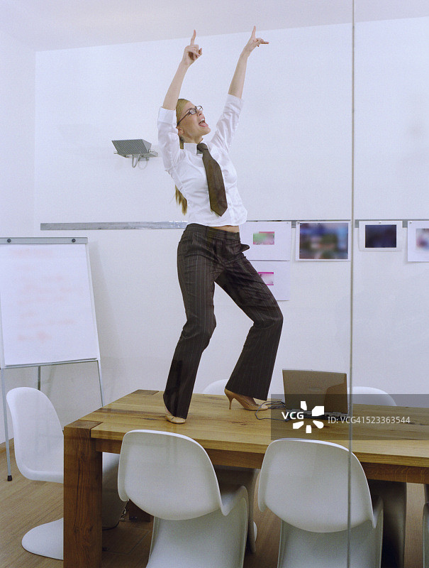 在办公室桌子上跳舞的女人图片素材