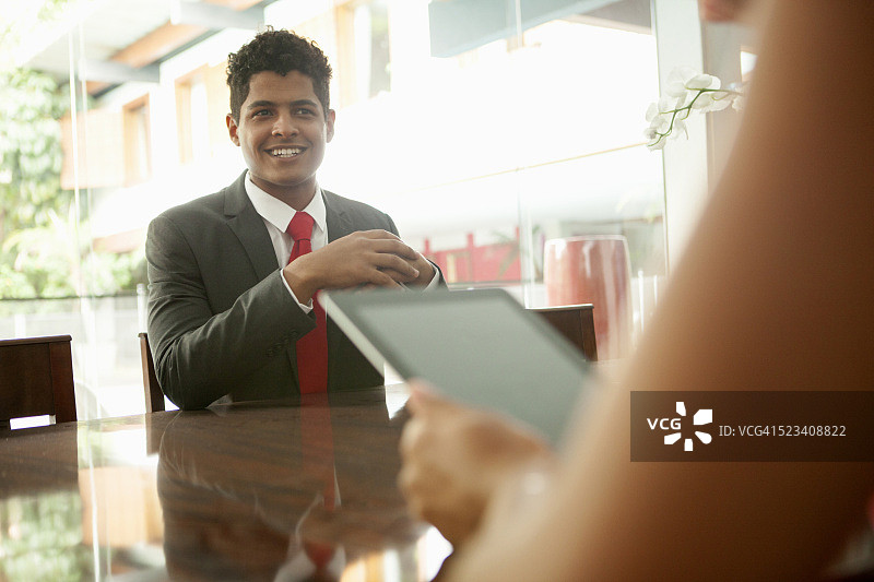 在巴西圣保罗会议桌旁微笑的商人图片素材