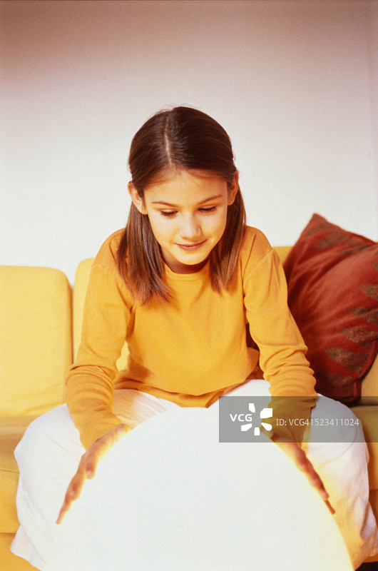 双手捧着白色圆球取暖的年轻女孩图片素材