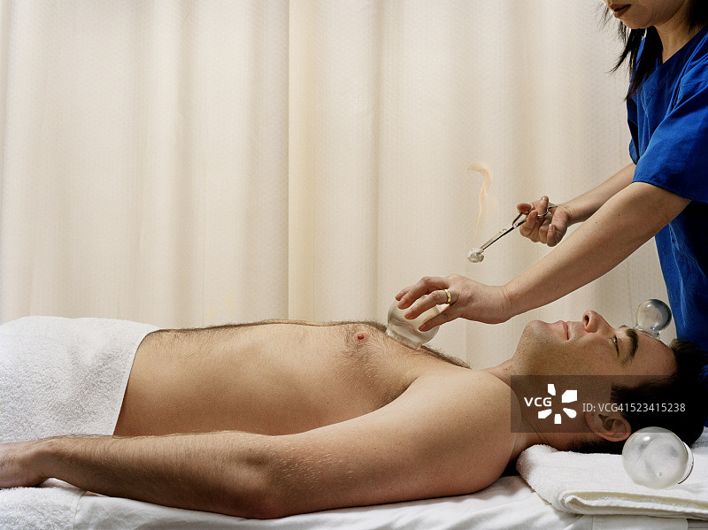 年轻男人接受拔罐治疗图片素材