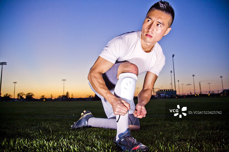 夕阳下在户外练习足球的运动员图片素材