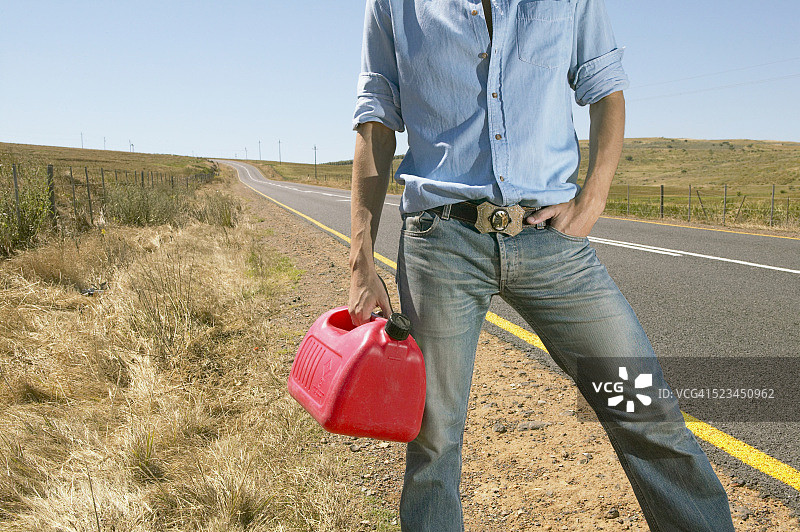 男人站在路边拿着油桶图片素材