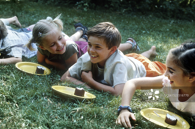 儿童花园中躺卧巧克力棉花糖盘前图片素材
