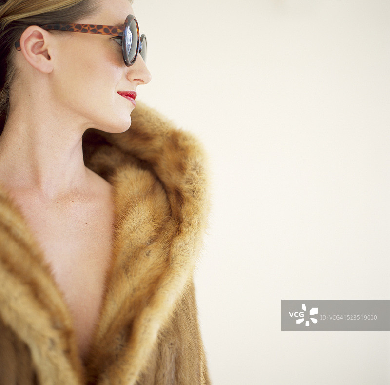 穿着皮草大衣和太阳镜的女人图片素材