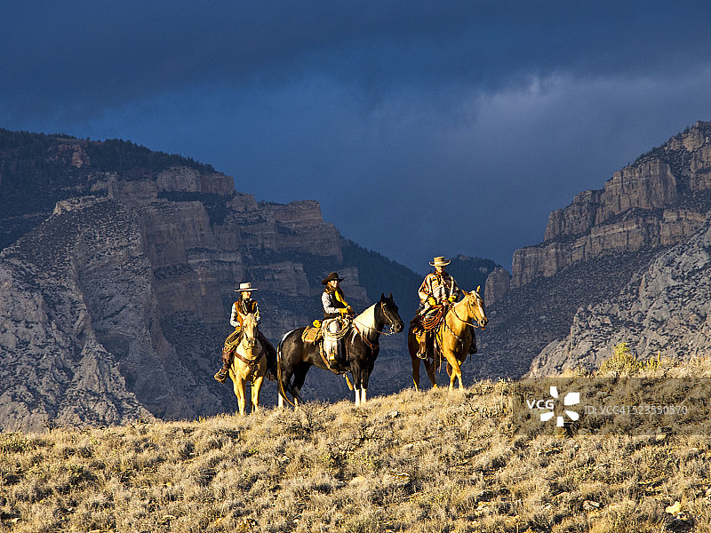 牛仔和女牛仔在Big Horn山丘上骑行图片素材
