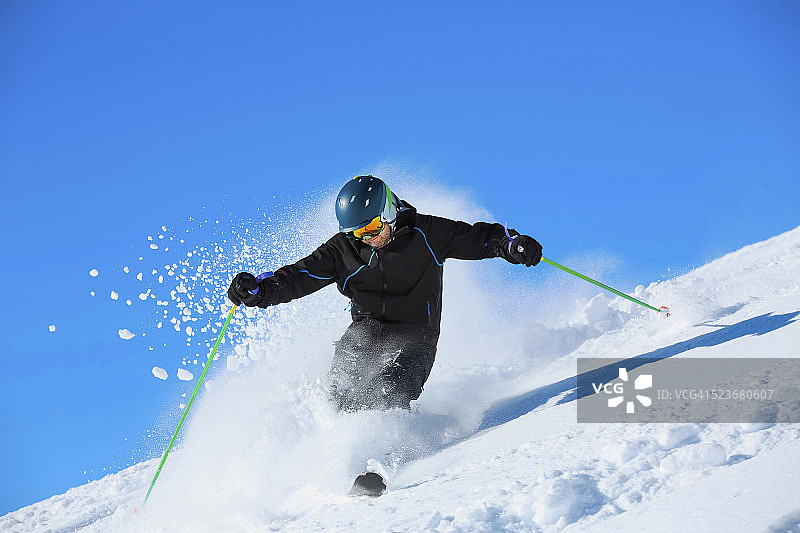 男人们在阳光明媚的滑雪胜地进行野雪粉雪滑雪图片素材