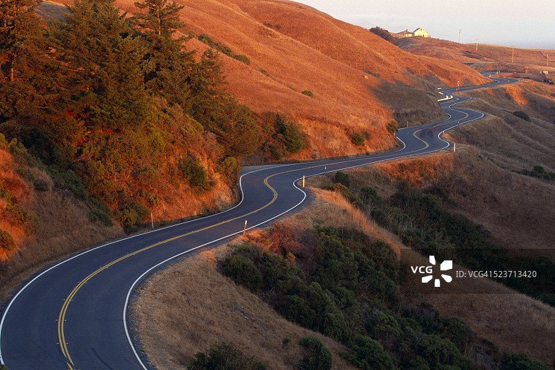 蜿蜒穿过山麓的乡村公路图片素材
