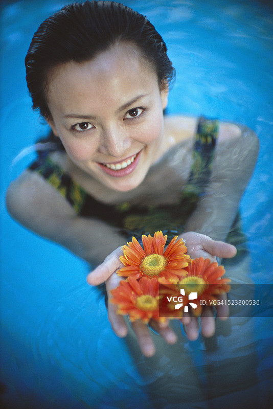 在泳池里拿着花的女人图片素材