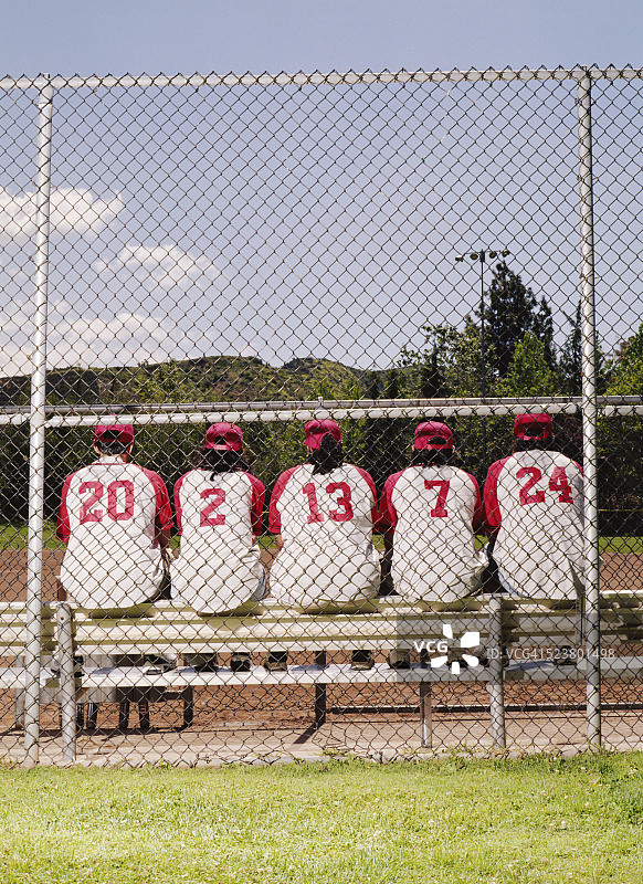 坐在长凳上的垒球运动员图片素材