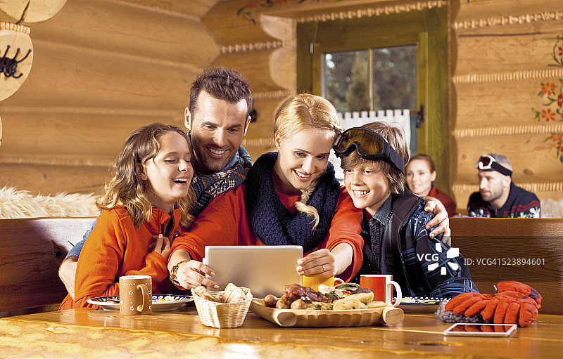 滑雪后一家人使用平板电脑共进午餐图片素材