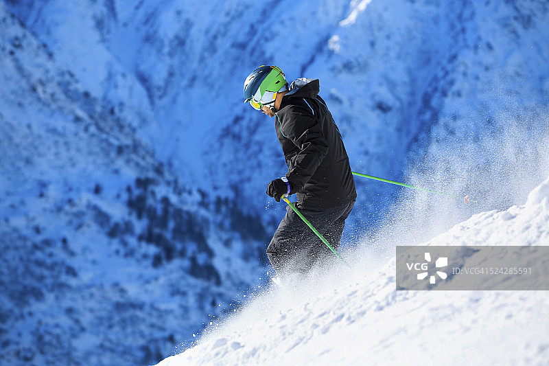 男人们在阳光明媚的滑雪胜地进行野雪粉雪滑雪图片素材