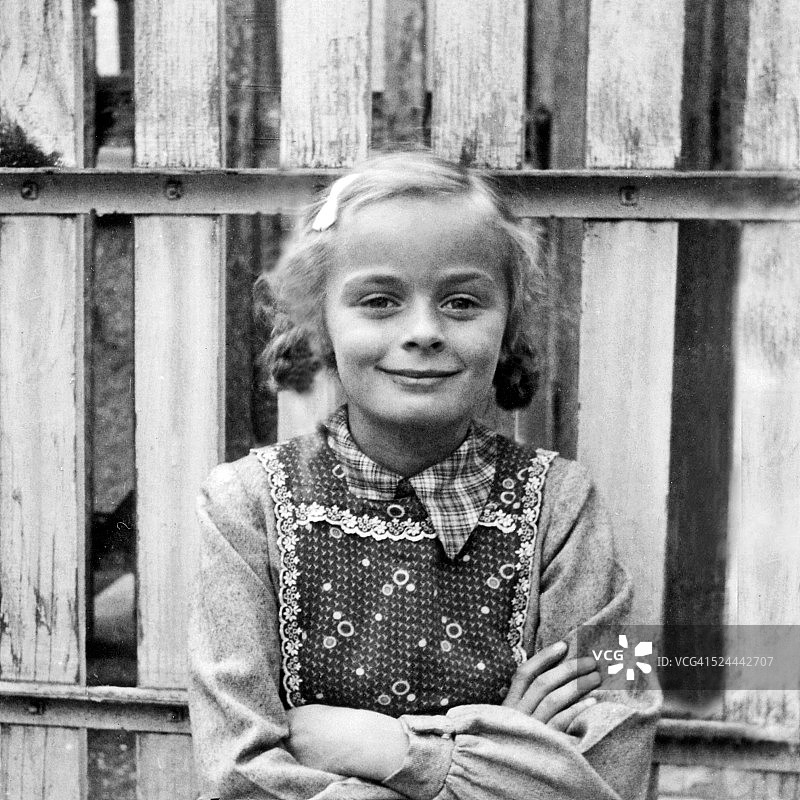 站在花园栅栏前的女孩图片素材