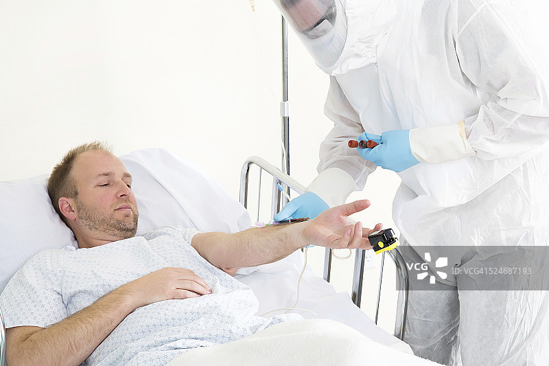 穿防护服的医务人员治疗传染病患者图片素材