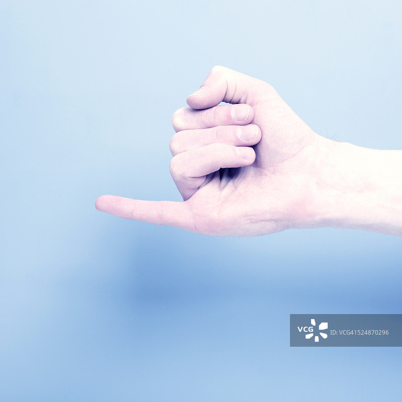 人手在蓝色背景上展示小拇指图片素材