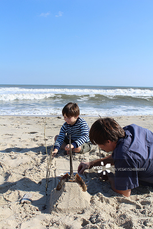 父亲和儿子建造沙堡图片素材