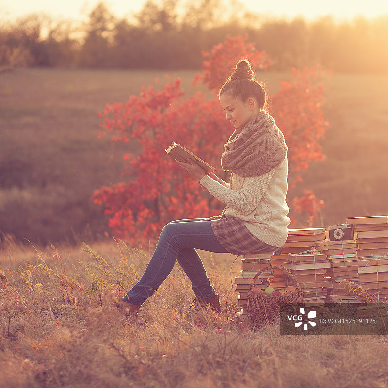 时尚女孩在日落时阅读图片素材