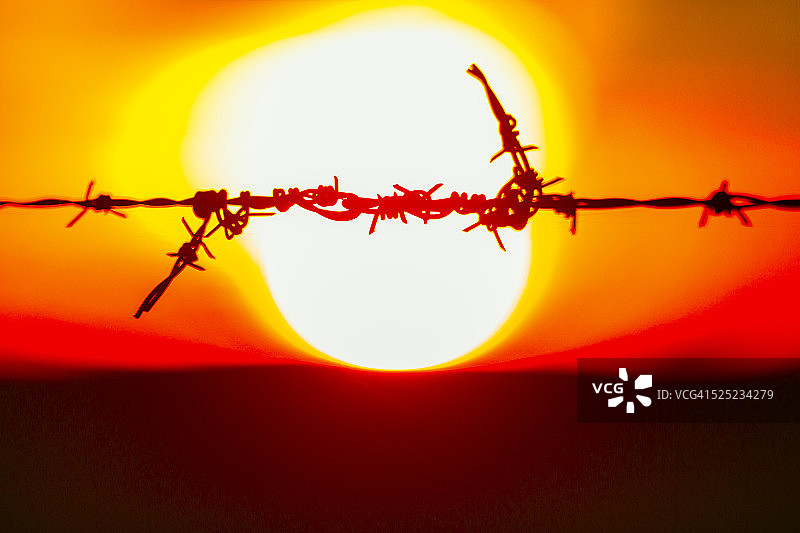 夕阳下的带刺铁丝网维修图片素材