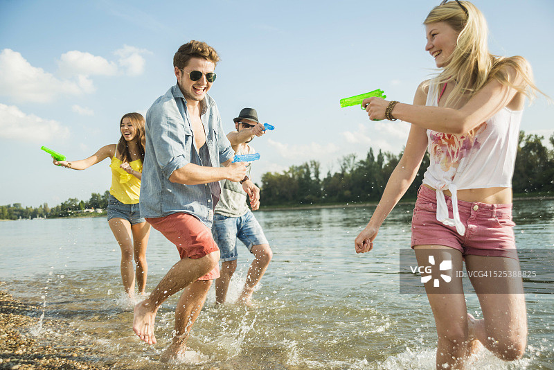 朋友们在湖里玩水枪图片素材