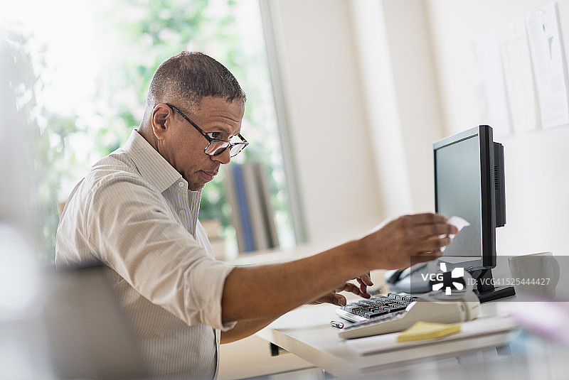 美国新泽西州泽西市，在家办公室内工作的中年男人图片素材