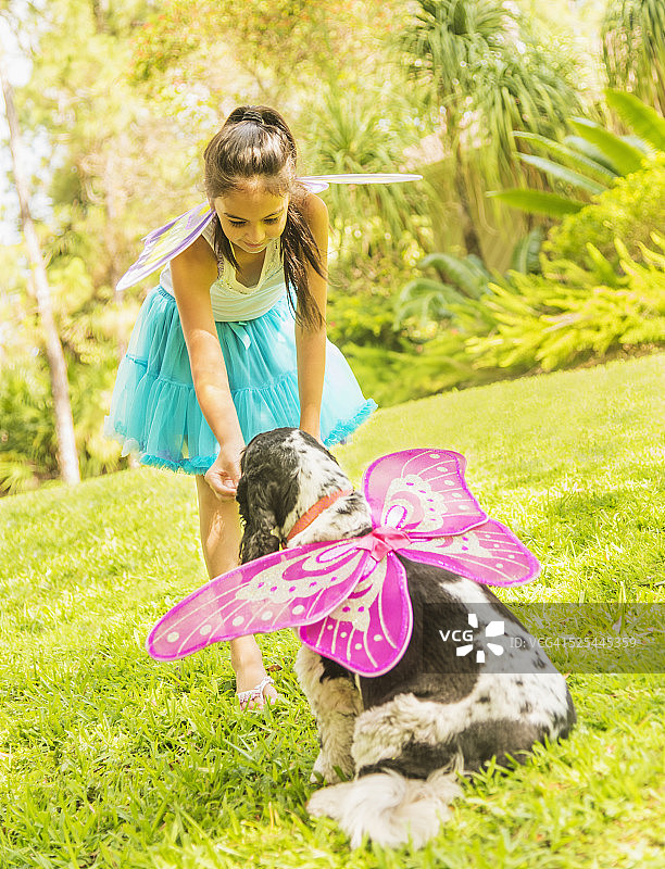 美国佛罗里达州朱庇特：女孩（8-9岁）装扮成仙女与狗玩耍图片素材