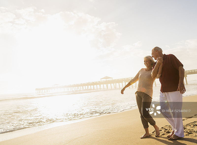 美国佛罗里达州朱庇特老年夫妇在海滩上散步图片素材