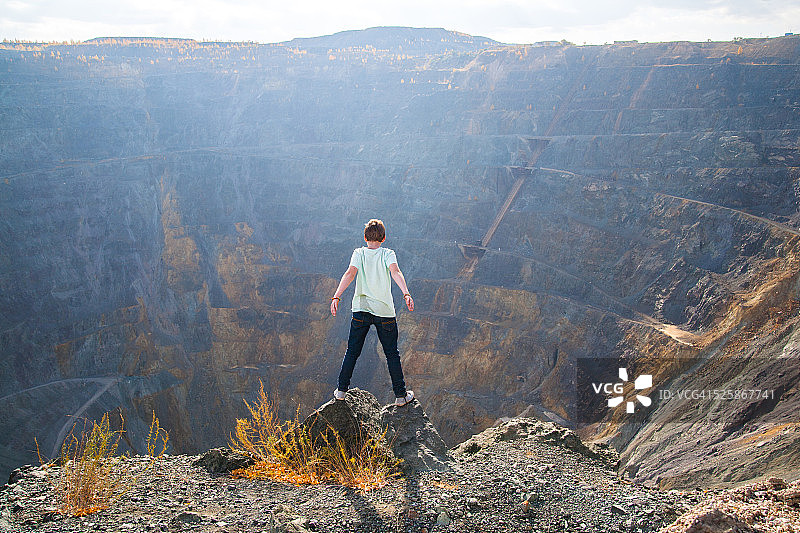 男孩站在深渊边缘图片素材