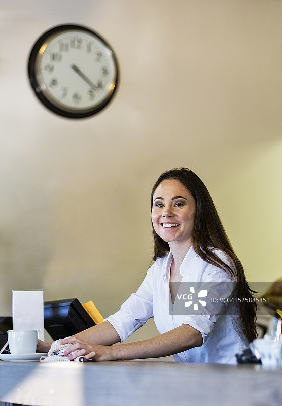 年轻女人在咖啡馆清洁柜台图片素材