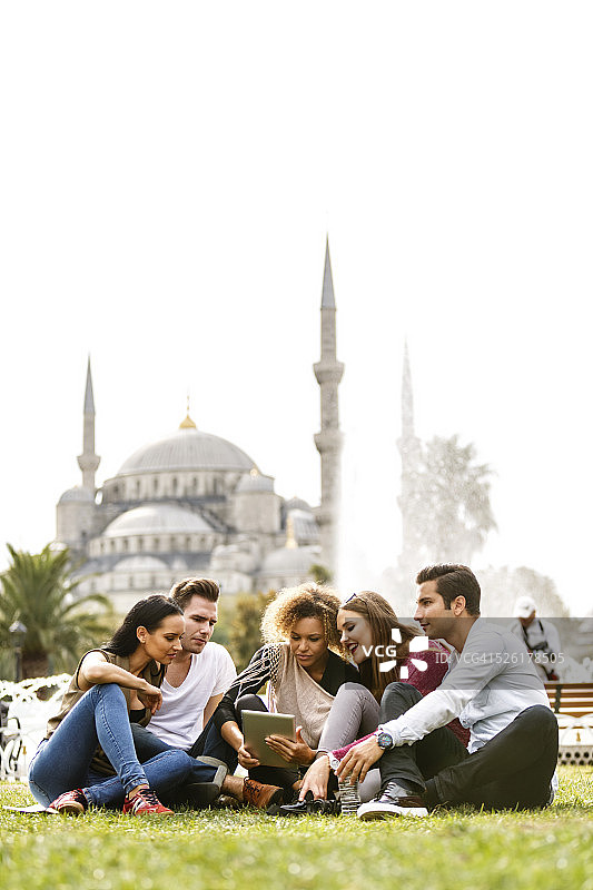 游客在伊斯坦布尔蓝色清真寺前使用平板电脑图片素材